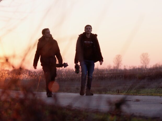 Die Zwillinge laufen auf einem Weg in den Sonnenuntergang.